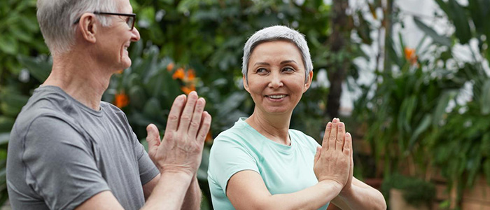 Two older adults doing yoga as chiropractic care supports healthy aging